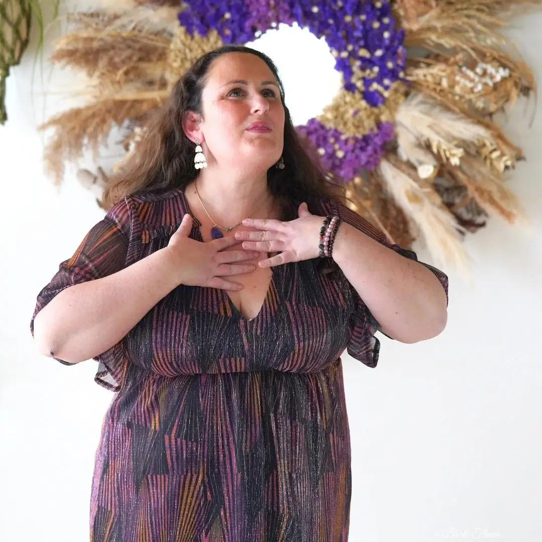 Christelle Parenti, les mains posées sur son cœur, un geste qui symbolise la reconnexion à son corps